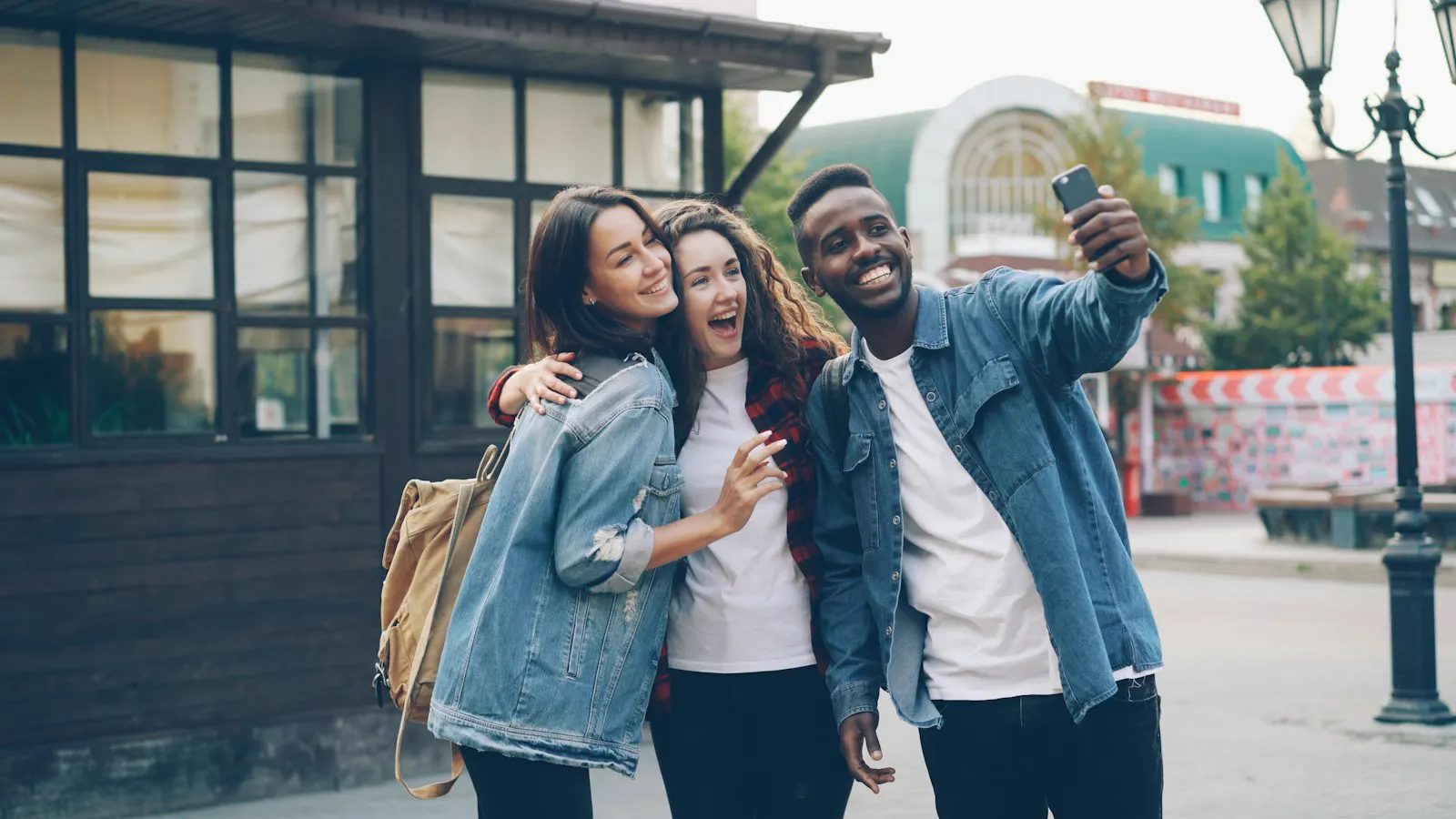 Trois amis qui se prennent en photo dans la rue